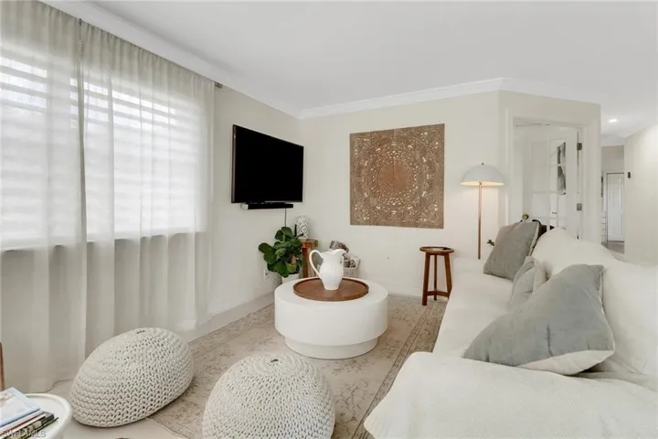 Living room with ornamental molding and baseboards