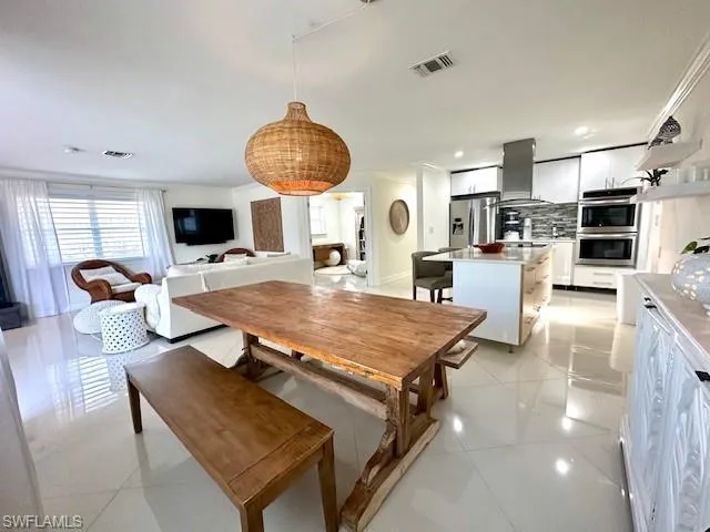 Dining area featuring crown molding and light tile patterned floors