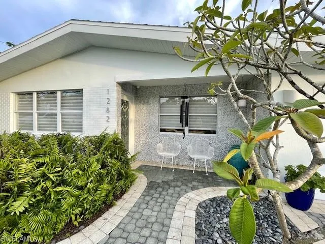 View of exterior entry featuring brick siding and a patio area
