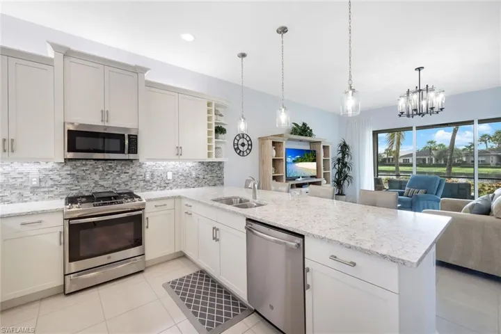 Kitchen featuring hanging light fixtures, sink, kitchen peninsula, a chandelier, and stainless steel appliances