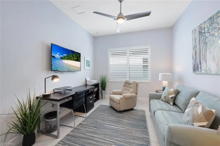 Living room with ceiling fan and tile patterned flooring