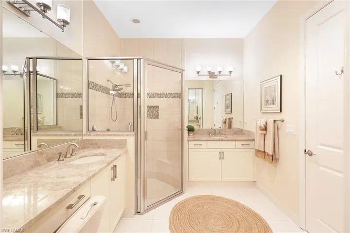 Bathroom with tile patterned flooring, vanity, and a shower with door