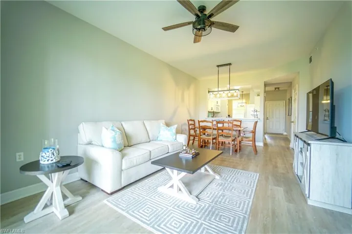 Living room with ceiling fan and light wood finished floors