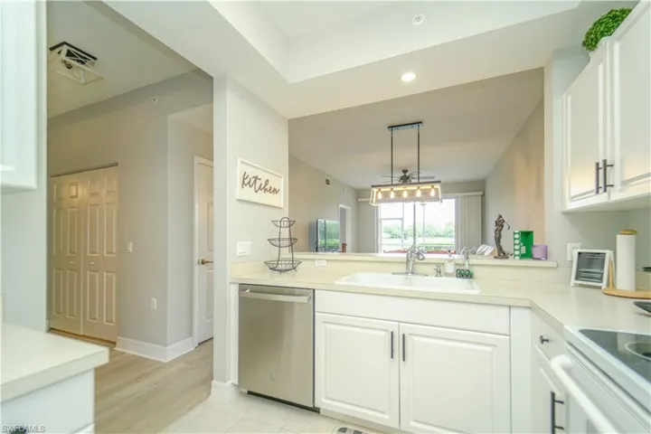 Kitchen with light countertops, white cabinets, dishwasher, and black range with electric cooktop