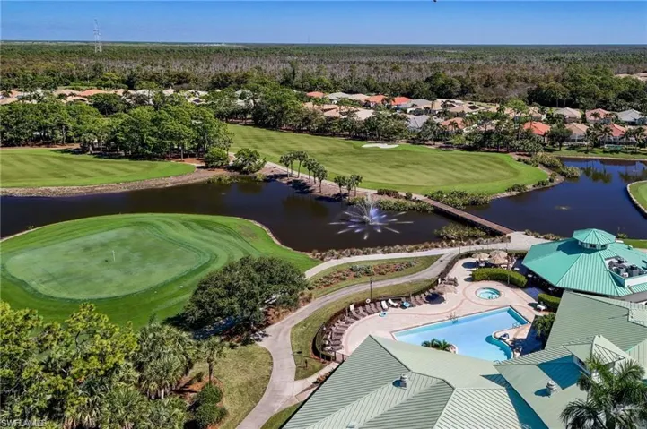 Aerial perspective of suburban area featuring a golf club and a nearby body of water