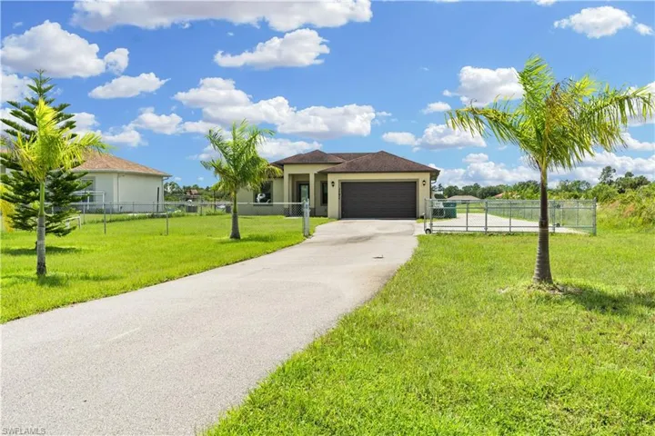 View of front of home with a garage and a front lawn
