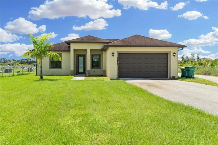 View of front of property featuring a garage and a front yard