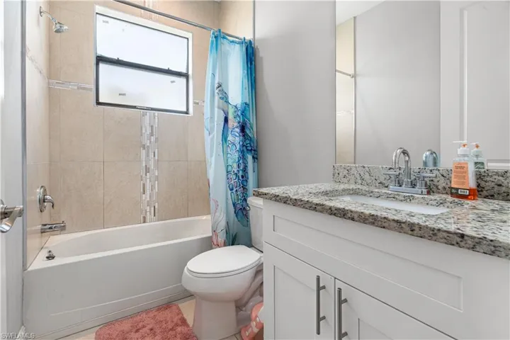 Full bathroom featuring vanity, toilet, and shower / tub combo with curtain
