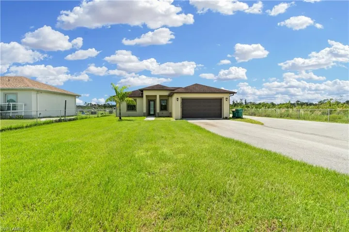 View of front of property with a garage and a front yard