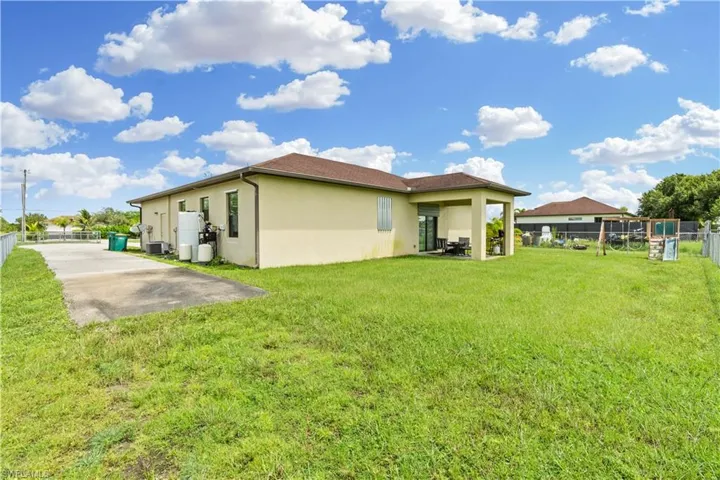 Rear view of house with a yard and a patio