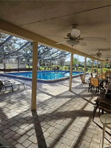 Pool with ceiling fan, a lanai, and a patio area
