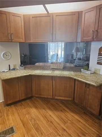 Kitchen featuring a peninsula, solid wood cabinets, granite countertops, built in desk and storage cabinets.