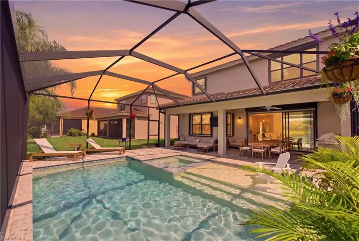 Screened lanai featuring a swimming pool, integrated spa, and paver decking