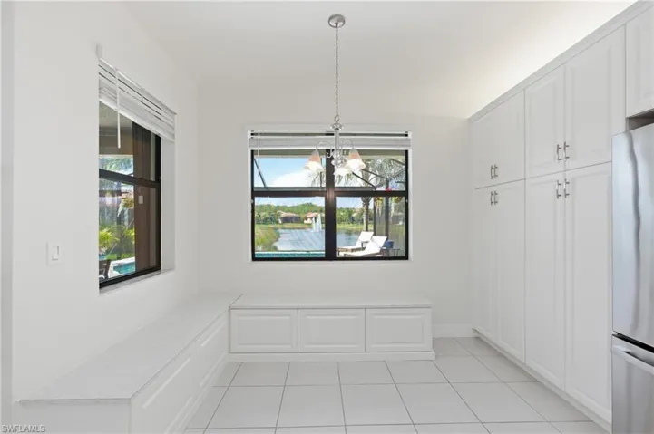 Built-in cabinetry and bench seating frame a window overlooking a water feature