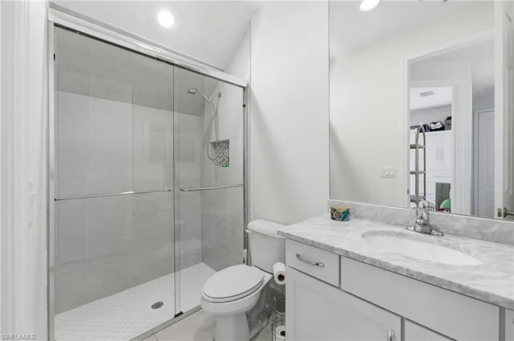 Bathroom featuring a glass-enclosed shower with subway tile surround and a built-in niche
