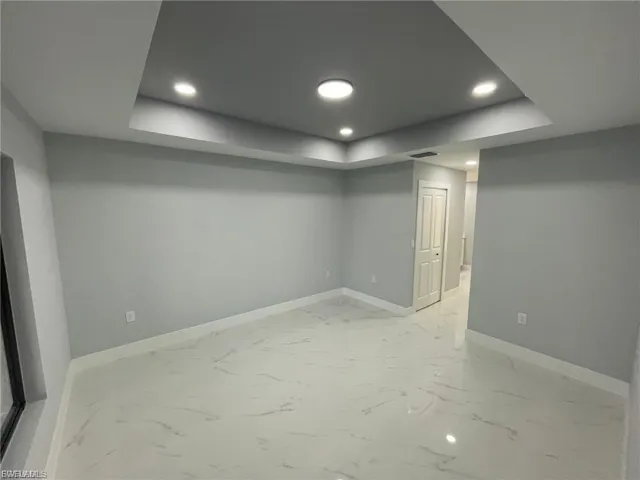 Basement with recessed lighting and light marble finish flooring