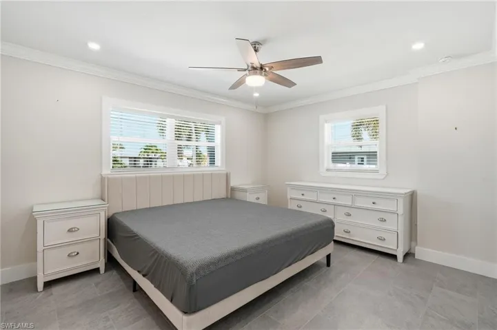 Spacious room featuring tile flooring, crown molding, recessed lighting, and a ceiling fan with light fixture