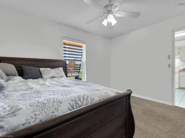 C21602 Carpeted bedroom featuring ceiling fan, a textured ceiling, and ensuite bathroom
