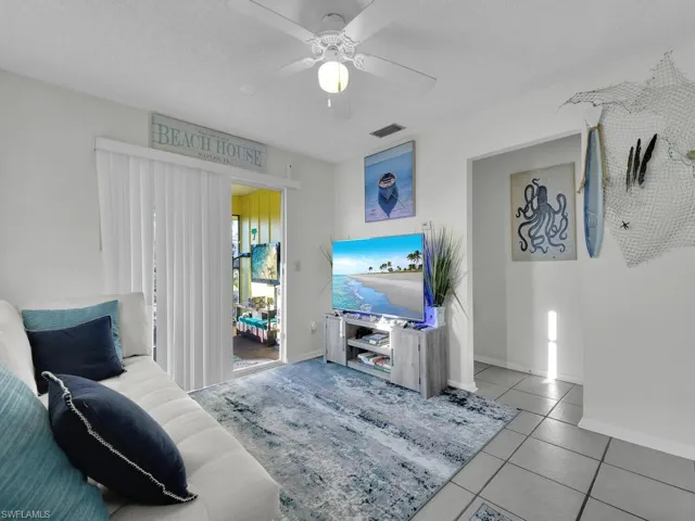 21602 Living room with a textured ceiling, ceiling fan, and light tile patterned floors