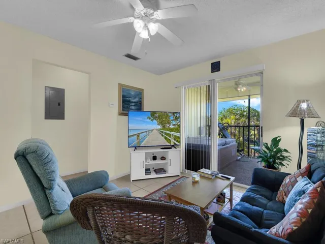 21600 Tiled living room featuring ceiling fan, a textured ceiling, and electric panel