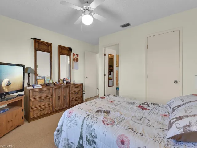 21600 Carpeted bedroom featuring ceiling fan and a textured ceiling