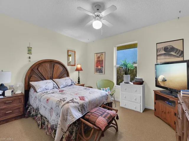 21600 Bedroom featuring ceiling fan, light colored carpet, and a textured ceiling
