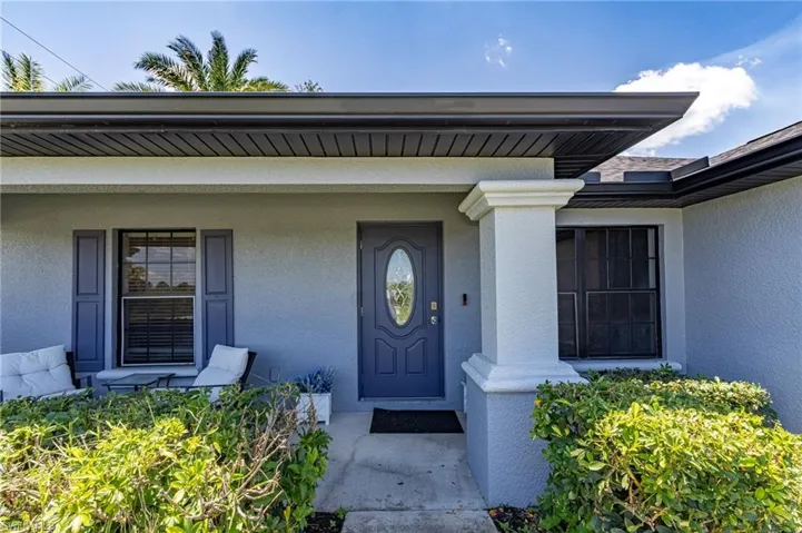 Property entrance with a porch and stucco siding