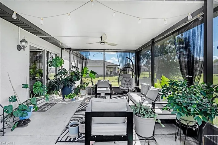 Screened lanai featuring a solid roof, ceiling fan, hardscaped concrete flooring, and metal-framed exterior walls