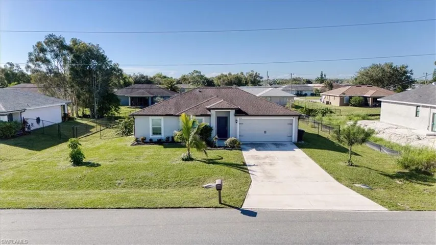 Single-story exterior featuring a hip roof, stucco facade, two-car garage, and a concrete driveway