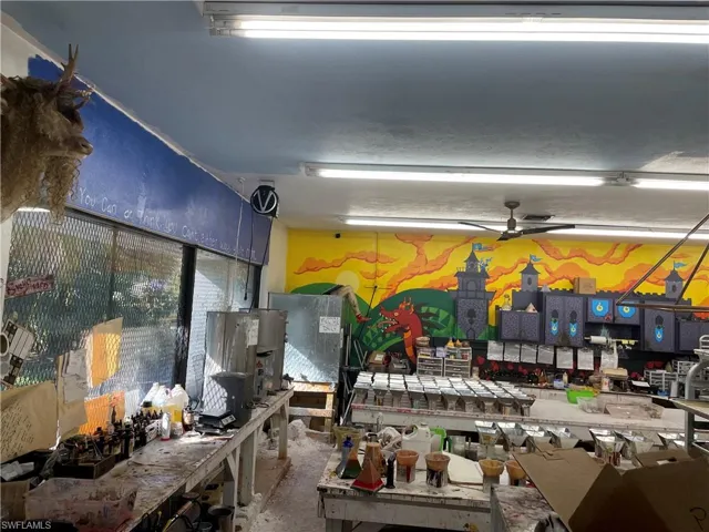 Miscellaneous room featuring a workshop area, ceiling fan, and concrete floors