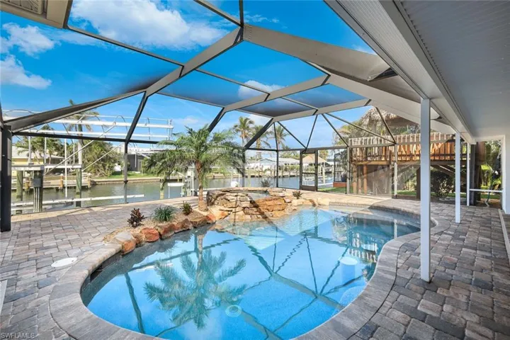 Pool featuring a patio, a water view, and glass enclosure