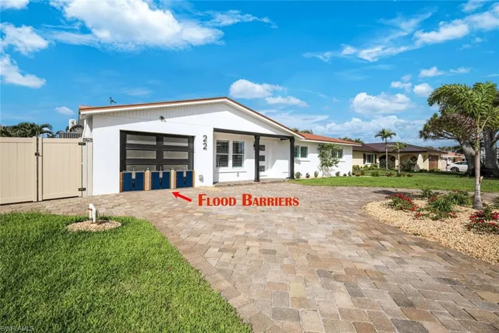 View of front of property featuring fence, a gate, and a front lawn