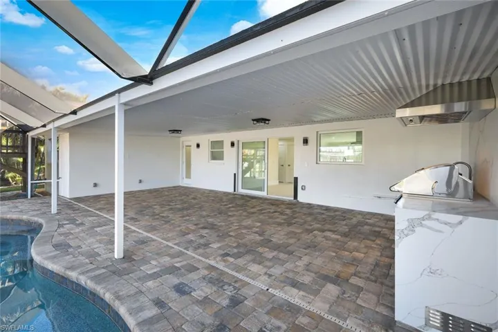 View of patio / terrace featuring an outdoor pool, glass enclosure, and area for grilling