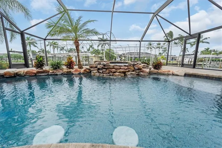 Outdoor pool with a sunroom and glass enclosure