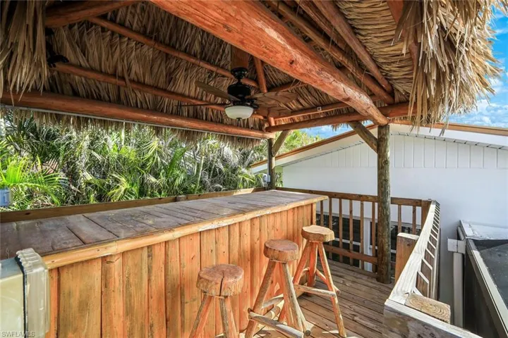 Wooden terrace featuring outdoor dry bar and ceiling fan
