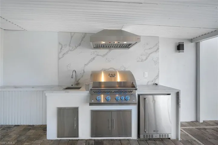 View of patio featuring a grill, an outdoor kitchen, and a sink