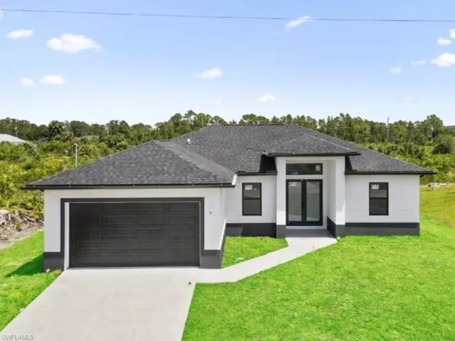 View of front of house featuring a front lawn and a garage