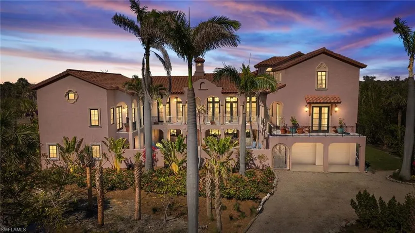 Mediterranean / spanish home featuring a tiled roof, driveway, a balcony, stucco siding, and a patio area