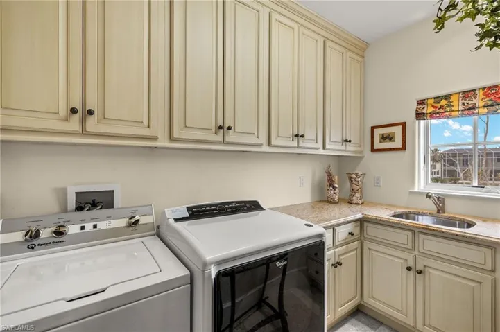 Laundry area featuring washer and clothes dryer and cabinet space