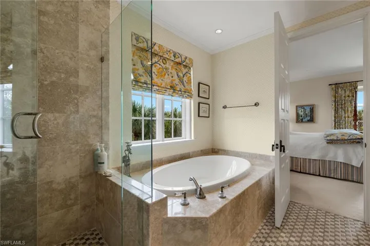 Bathroom featuring connected bathroom, crown molding, a bath, a stall shower, and recessed lighting