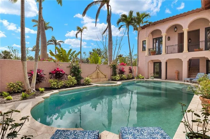 View of swimming pool with a fenced backyard, a pool with connected hot tub, a patio area, and a balcony