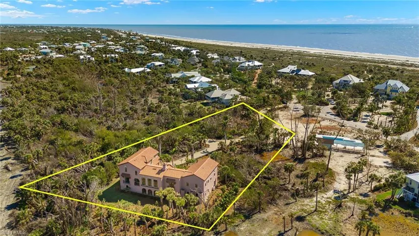 Aerial perspective of suburban area with expansive beach and property parcel outlined