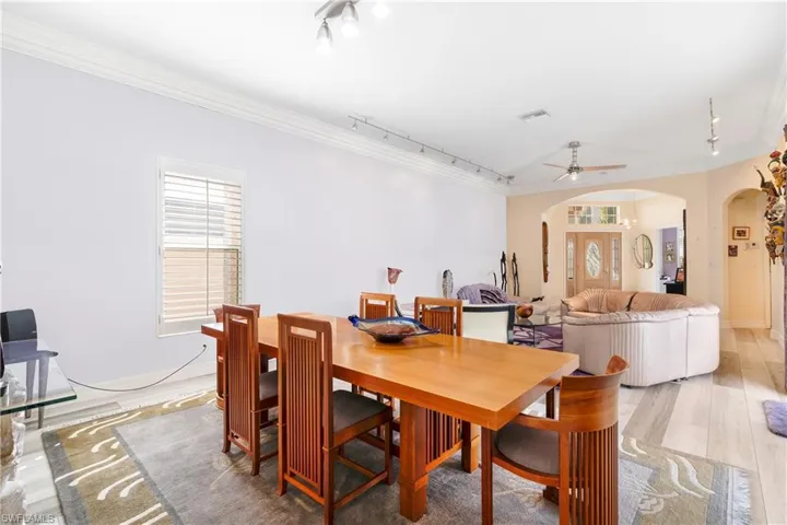 Dining room with ornamental molding, hardwood / wood-style floors, rail lighting, and ceiling fan