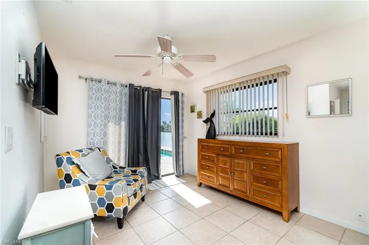 2nd master Bedroom featuring light tile patterned floors, and a ceiling fan and 2 closets, to left of this is the open space sitting room