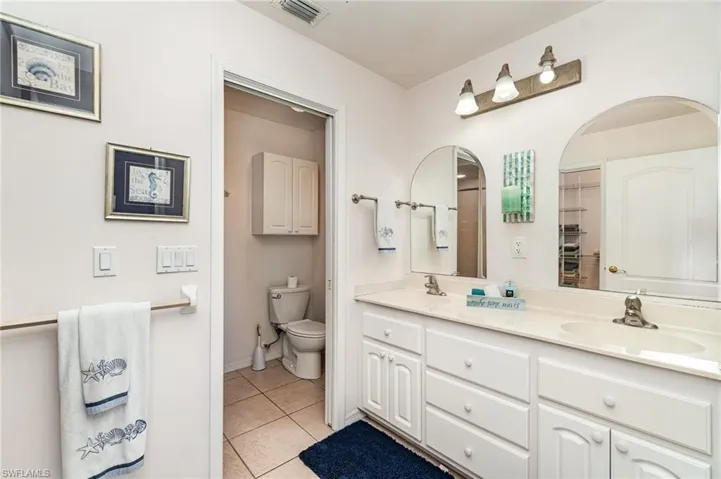 Primary Master Bedroom with access to outside, light tile patterned flooring, a water view, and plantation shutters!