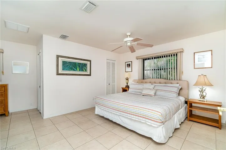 Kitchen featuring white self cleaning electric range, above range microwave, stainless steal refeigerator with ice maker, light tile flooring, white cabinetry, granite countertops and crown molding