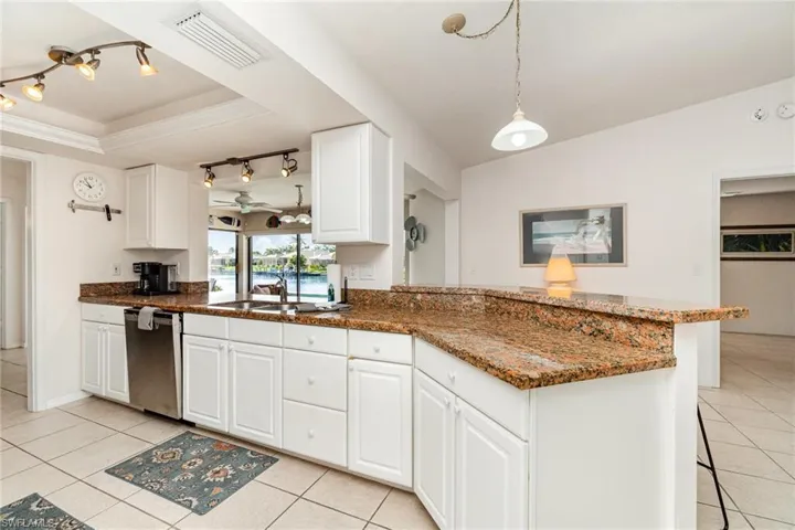 Kitchen with stainless steal dishwasher, a double basin sink, ganite countertops, 2 rail lighting fixtures and crown molding