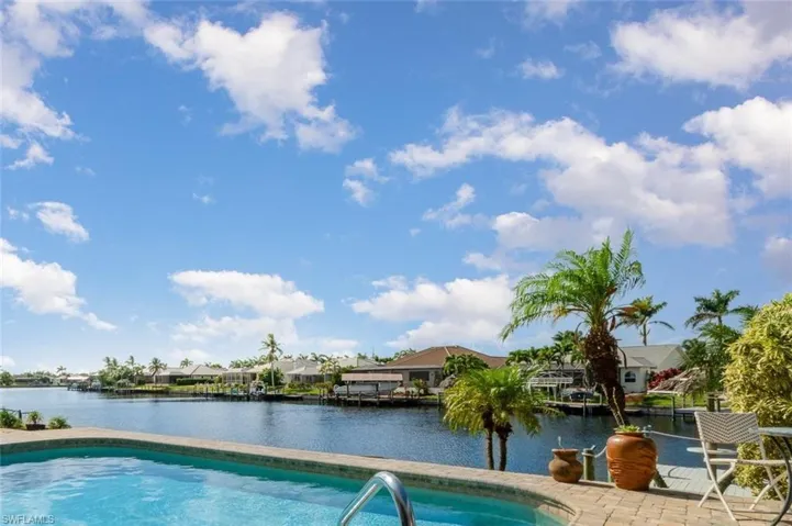 Swimming pool with amazing water views featuring a lounge area and small bistro table and chairs to the right