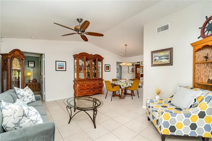 Foyer and Living room featuring vaulted ceiling, a ceiling fan and the light tile floorin