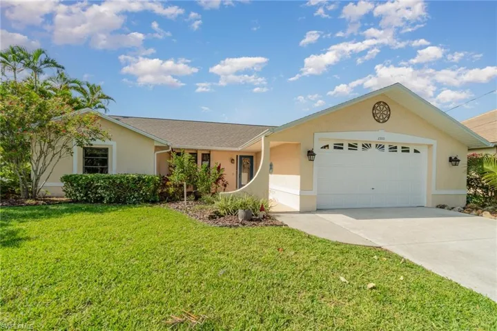 Single story home with stucco siding, a 2 car attached garage, concrete driveway, and a front lawn